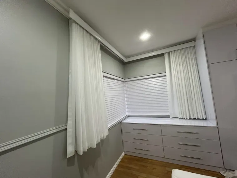 White wave curtains with venetian blinds wrapping a corner in a Cape Town dressing room