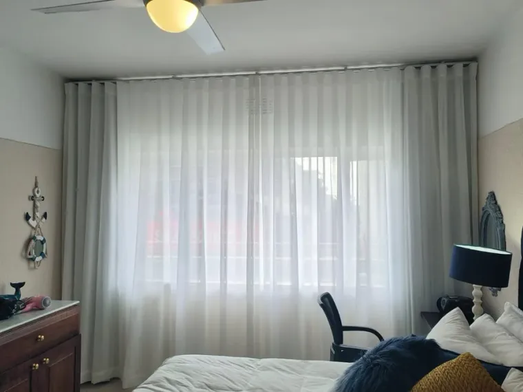 White sheer curtains fitted floor to ceiling in a Cape Town bedroom