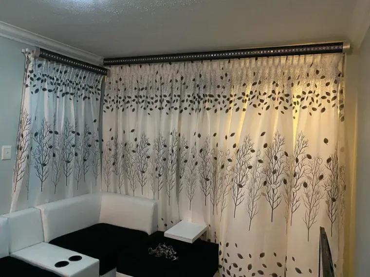 White curtains with a black tree-and-leaf print fitted in a Cape Town lounge