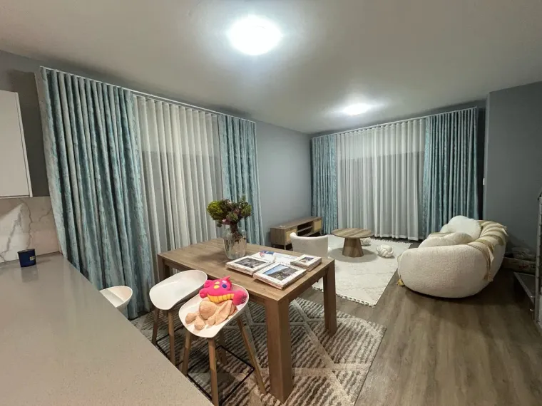 Teal wave curtains with sheers in an open-plan Cape Town living area