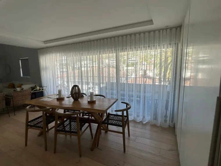 White sheer wave-pleat curtains in a Cape Town dining room
