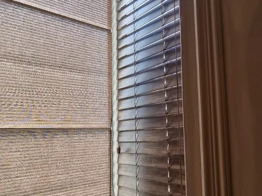 Natural woven roman blind beside a wood-tone venetian blind in a Cape Town home