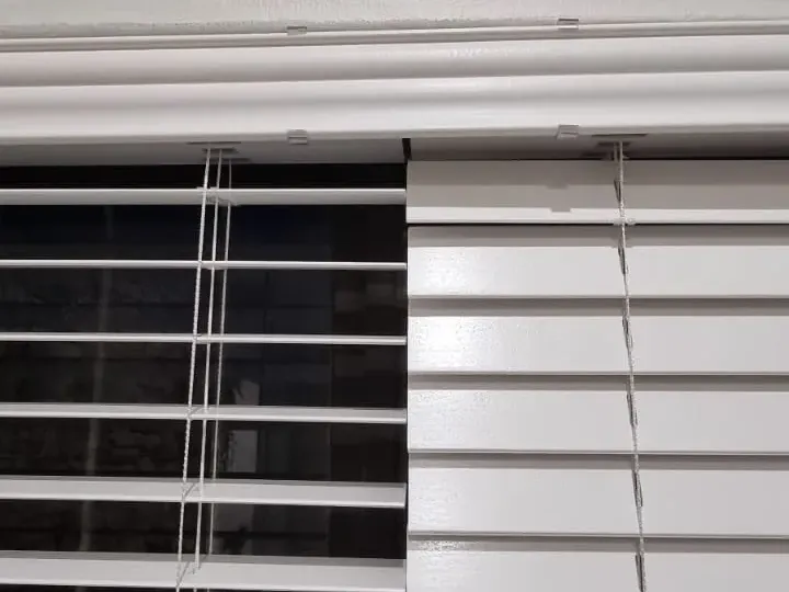White wide-slat venetian blinds, close-up detail