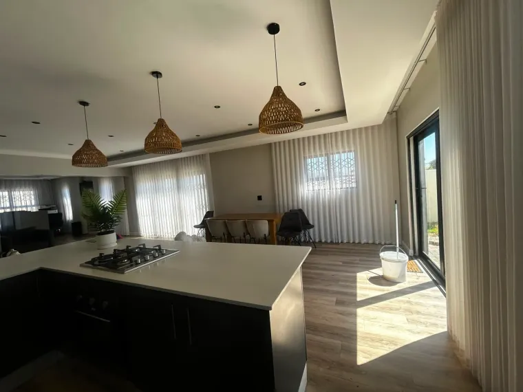 White sheer curtains in an open-plan Cape Town kitchen and dining area